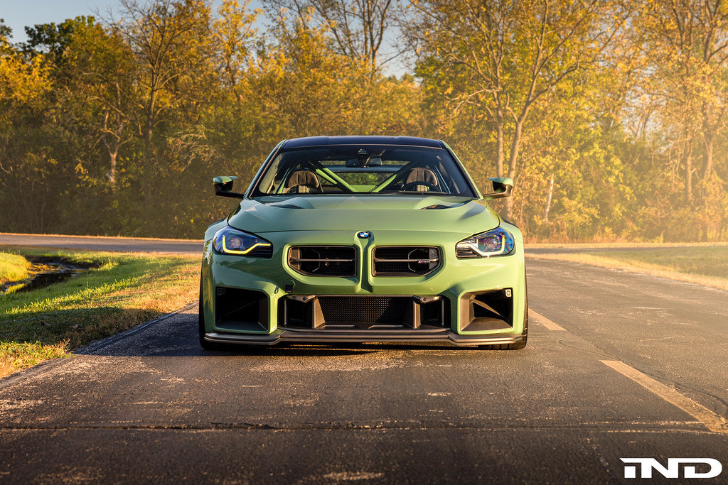 Alpha N G87 M2 carbon adjustable front lip installed on a BMW G87 M2, enhancing the vehicle's sporty exterior with a sleek design.