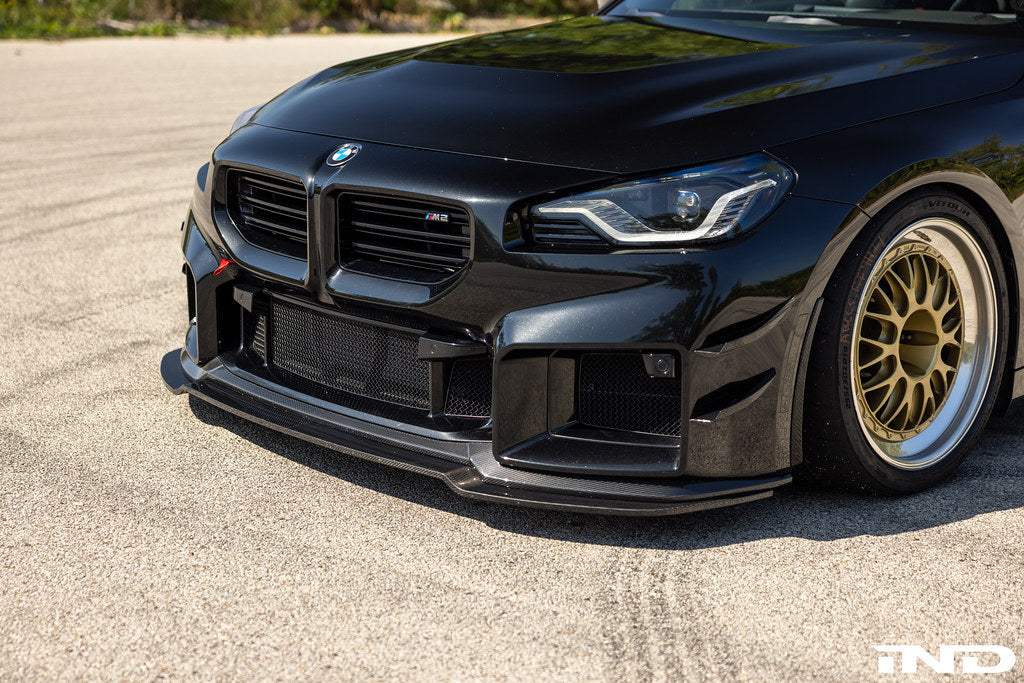 Alpha N G87 M2 carbon bumper canard set installed on the exterior of the vehicle, enhancing aerodynamics and sporty appearance.