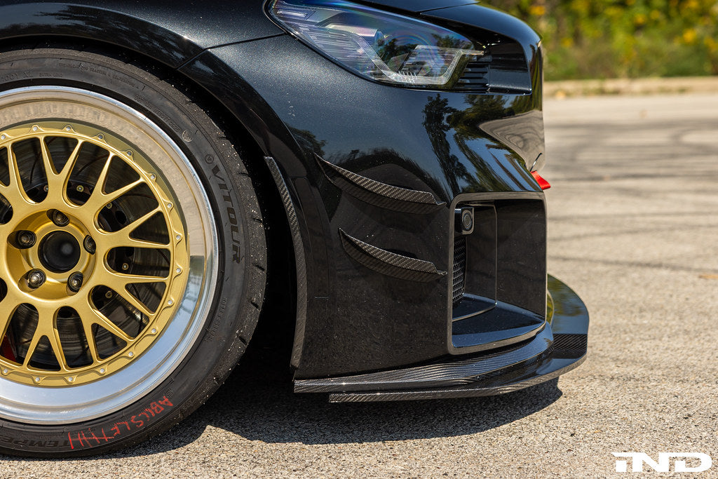 Alpha N G87 M2 carbon bumper canard set installed on vehicle, showcasing aerodynamic exterior enhancements for the BMW M2.