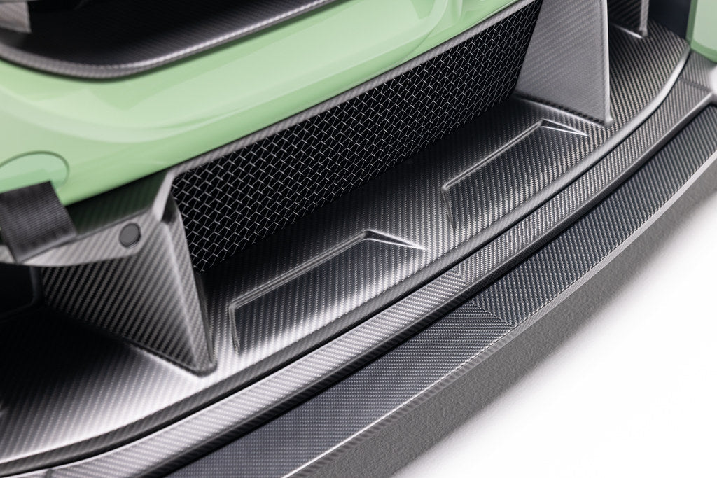 Alpha N G87 M2 carbon front center bumper trim installed on a vehicle's exterior, showcasing sleek carbon fiber detail.