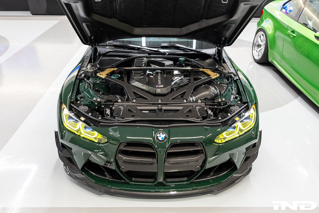 Alpha N G8X M3 M4 carbon front grille with canard set installed on exterior of vehicle, showcasing sleek carbon fiber design.
