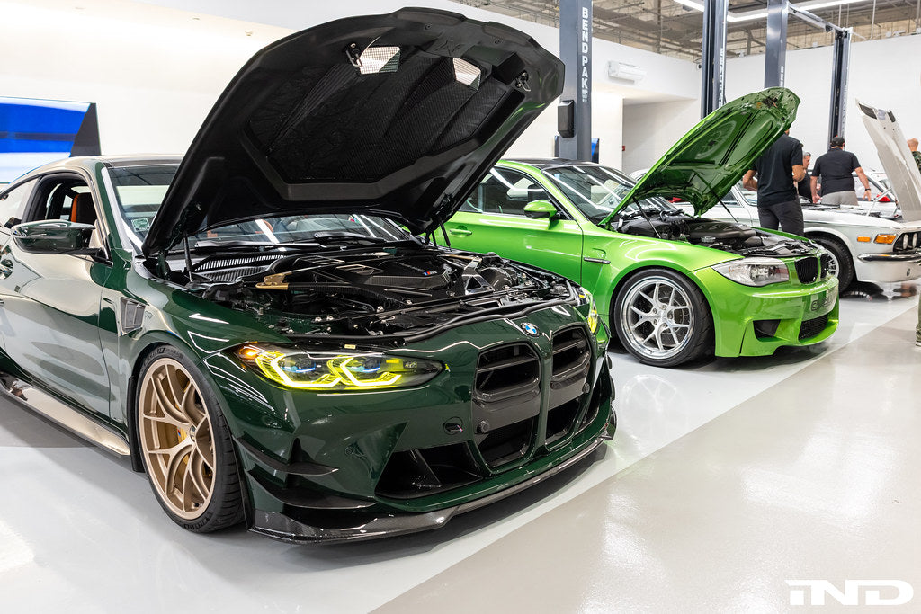Alpha N G8X M3 M4 carbon front spoiler installed on vehicle, showcasing sleek exterior design and aerodynamic features.