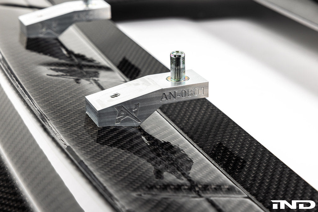 Alpha N G87 M2 Carbon Corse front splitter installed on a car, showcasing its aerodynamic design and lightweight carbon fiber material.