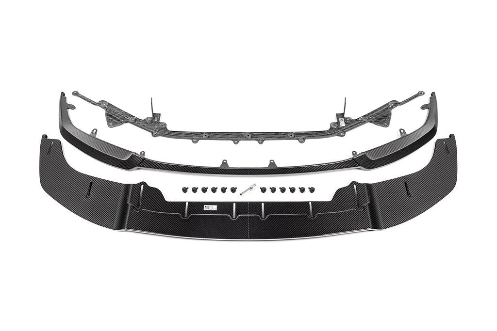 Alpha N Alpha-N G87 M2 Carbon Adjustable Front Lip Class 3 installed on a vehicle, showcasing its sleek white design and aerodynamic style.
