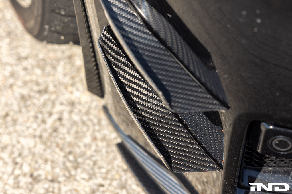 Alpha N G87 M2 Carbon bumper canard set installed on car, showcasing aerodynamic exterior upgrade with sleek carbon fiber design.