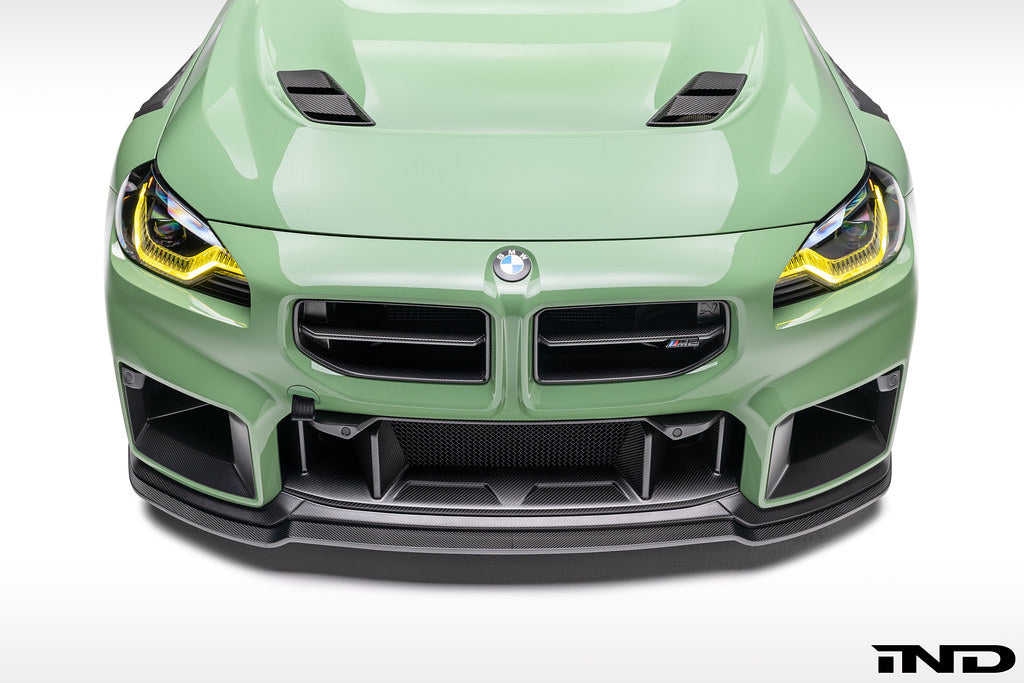 Alpha N G87 M2 carbon front center bumper trim installed on the exterior of a vehicle, showcasing sleek, lightweight design.
