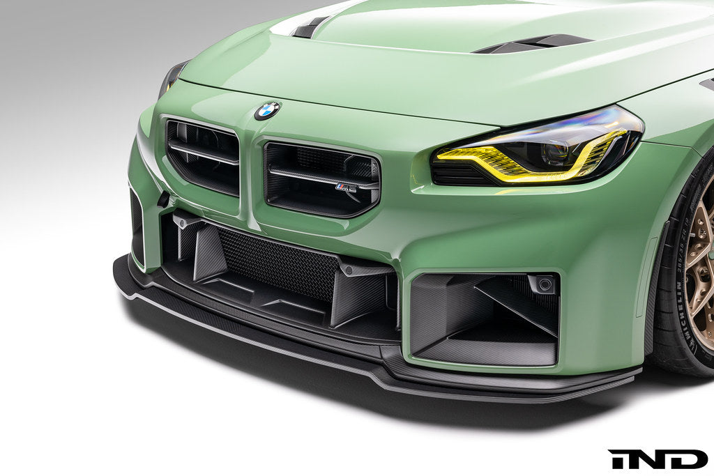 Alpha N G87 M2 carbon front center bumper trim installed on vehicle exterior, showcasing sleek, lightweight carbon fiber design.