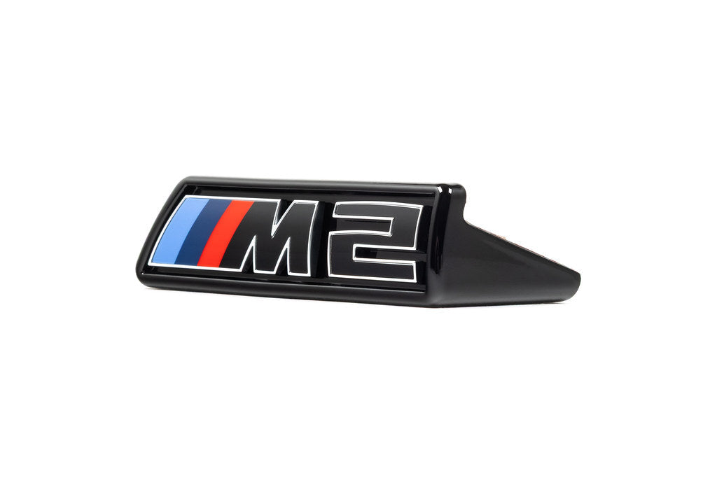 Alpha-N G87 M2 LCI front grille emblem retainer with OEM M2 badge on white background, for BMW M2 exterior accessories.