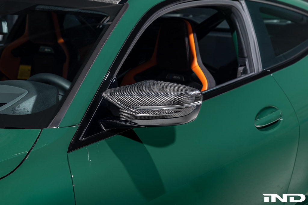 Alpha N G8X M2 M3 M4 carbon mirror cap set installed on vehicle exterior, showcasing sleek black carbon fiber finish.