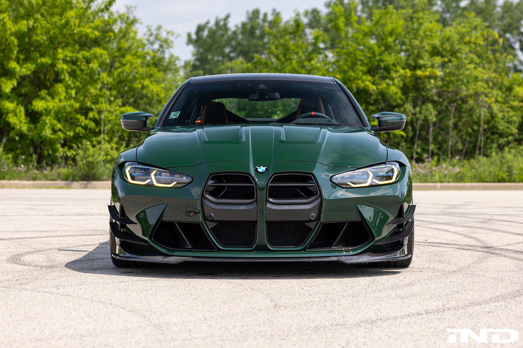Alpha N G8X M3 M4 carbon front spoiler installed on vehicle, showcasing sleek exterior design and aerodynamic enhancements.
