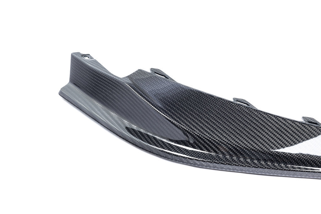 Alpha N G8X M3 M4 carbon front spoiler mounted on a white background, showcasing its aerodynamic design and lightweight carbon material.