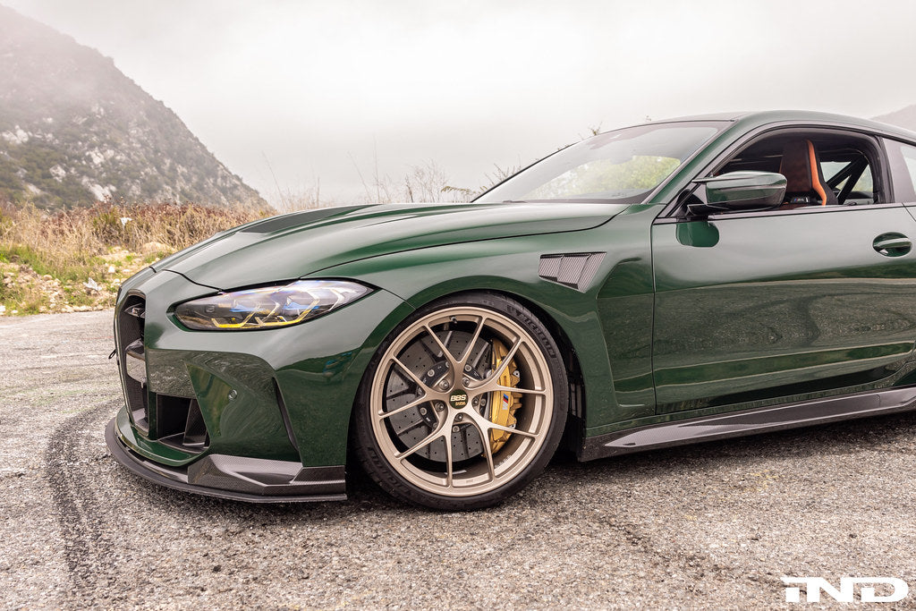 Alpha N G8X M3 M4 carbon vented front fender set installed on a BMW G8X M3 M4 exterior car body.