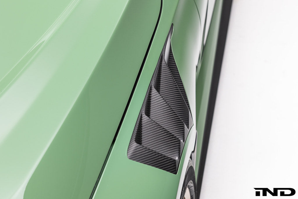Alpha N G87 M2 carbon vented front fender set with blades installed on vehicle, showcasing lightweight, aerodynamic exterior design.